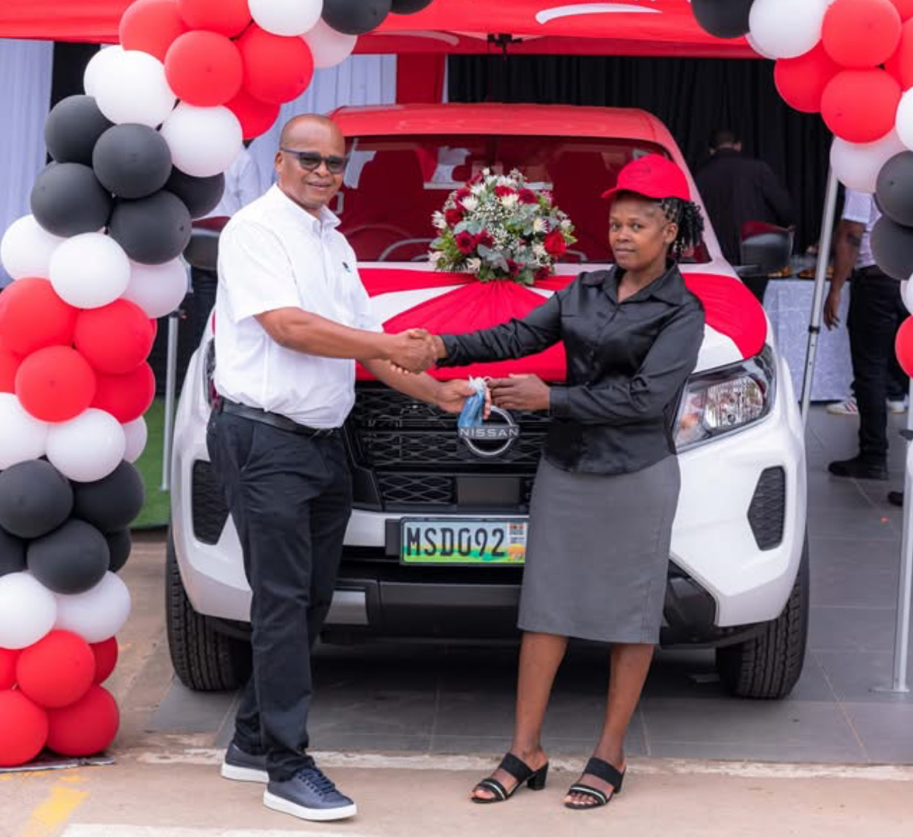 Ok Foods Eswatini Director Lincon Motsa hands another car to Nyakatfo Primary School teacher Hilda Gule, winner describes gift as a surprise.