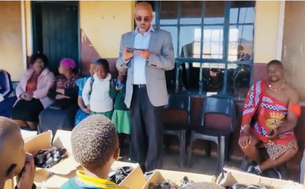 Ex-Swazi Mobile senior Manager Benedict Bennett urges LaMgabhi Primary School children to prioritize education, representing editor Zweli Martin Dlamini during shoes donation.