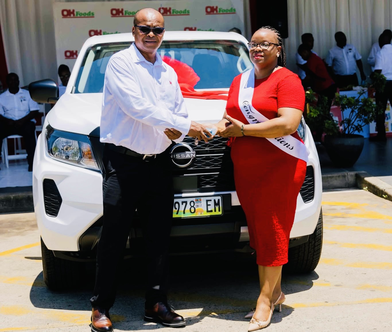 Ok Foods Eswatini Director Lincon Motsa hands over R500,000.00 new Navara to winner Khetsiwe Zwane.